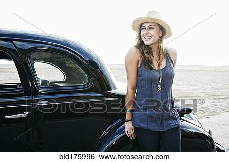 Stock Photograph - Woman standing near vintage car. Fotosearch