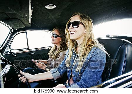 Stock Image - Women driving vintage car. Fotosearch