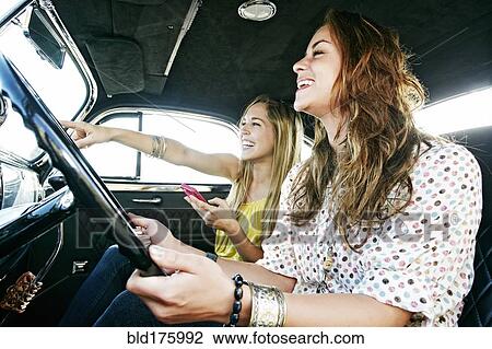 Stock Image - Women driving vintage car. Fotosearch