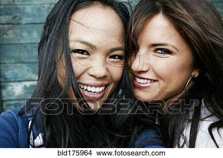 Picture - Women laughing at wooden wall. Fotosearch