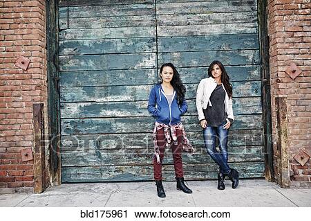Women standing at wooden wall View Large Photo Image Stock Image - Women standing at wooden wall. Fotosearch