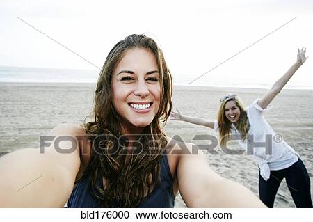 Stock Image - Women taking selfie on beach. Fotosearch