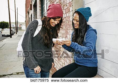 Women using cell phone outdoors View Large Photo Image Stock Photography - Women using cell phone outdoors. Fotosearch