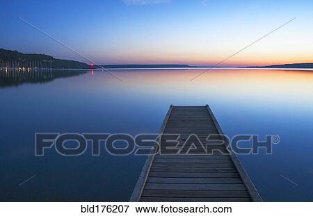 Stock Photo - Wooden dock over still lake. Fotosearch