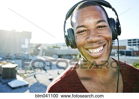 African American man listening to headphones on urban rooftop View Large Photo Image Stock Image - African American man listening to headphones on urban rooftop. Fotosearch