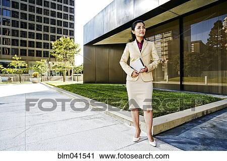 Stock Image - Asian businesswoman standing outdoors. Fotosearch