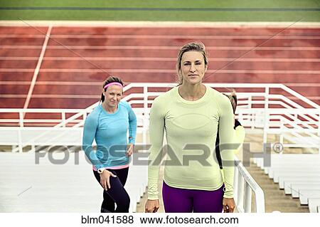 Stock Photo - Athletes standing on bleachers. Fotosearch
