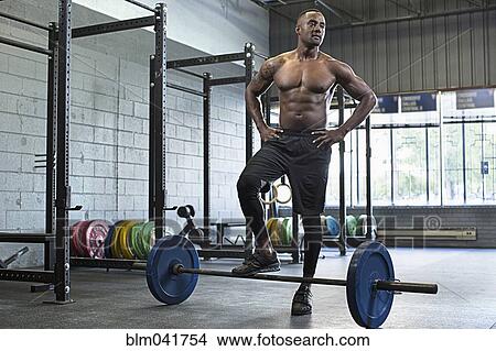 Black athlete standing at barbell in gym View Large Photo Image Picture - Black athlete standing at barbell in gym. Fotosearch