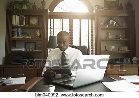 Black doctor using digital tablet in office View Large Photo Image Stock Image - Black doctor using digital tablet in office. Fotosearch