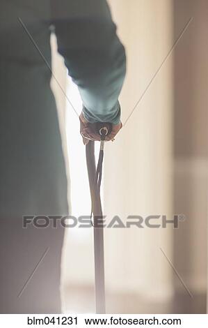 Stock Image - Black man holding cane. Fotosearch