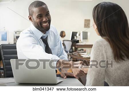 Business people shaking hands in office View Large Photo Image Stock Photo - Business people shaking hands in office. Fotosearch
