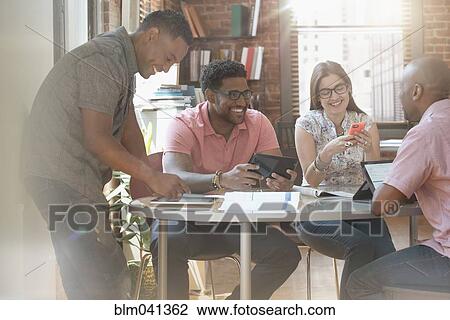 Stock Image - Business people talking in office meeting. Fotosearch