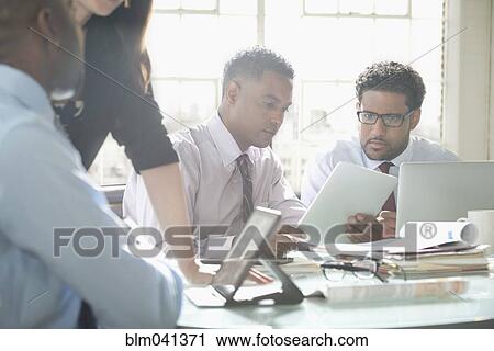 Stock Image - Business people talking in office meeting. Fotosearch