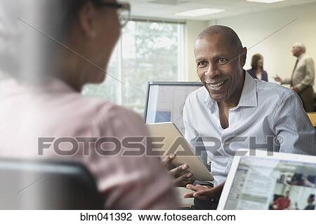 Stock Image - Business people talking in office. Fotosearch