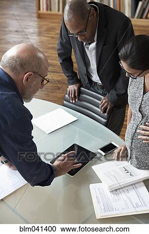 Business people using digital tablet in office View Large Photo Image Stock Image - Business people using digital tablet in office. Fotosearch