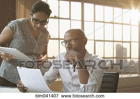 Stock Photo - Business people using digital tablet in office. Fotosearch