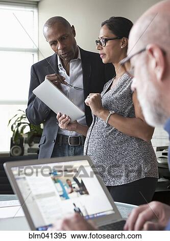 Business people using digital tablet and laptop in office View Large Photo Image Stock Photography - Business people using digital tablet and laptop in office. Fotosearch