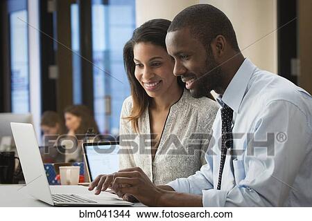 Picture - Business people using laptop in office. Fotosearch