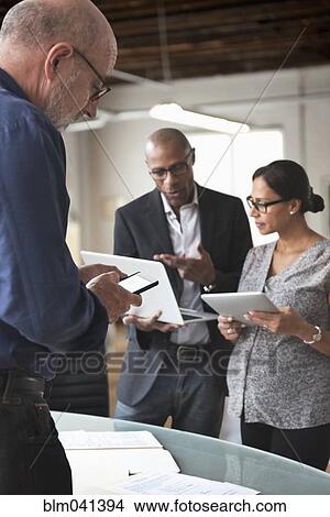 Picture - Business people using technology in office. Fotosearch