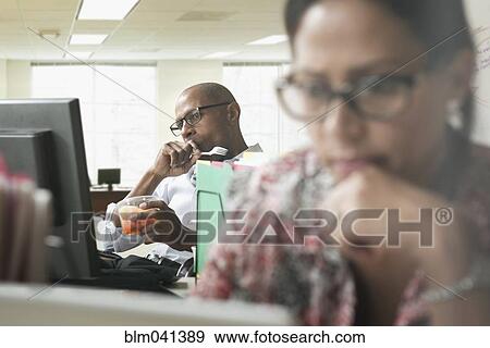 Stock Photo - Business people working in office. Fotosearch