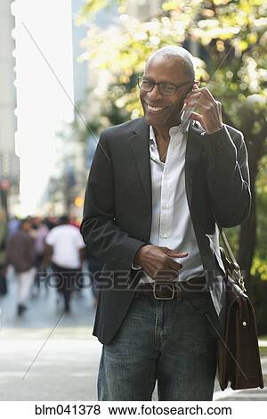 Stock Photo - Businessman talking on cell phone outdoors. Fotosearch
