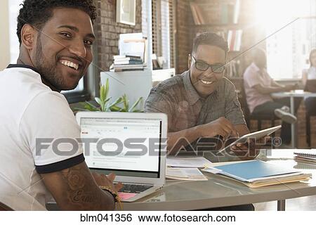 Stock Photograph - Businessmen smiling in office. Fotosearch