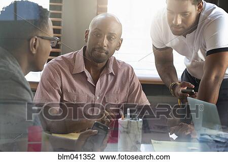 Stock Image - Businessmen talking in office meeting. Fotosearch