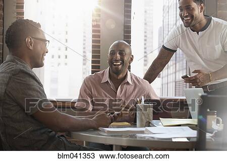 Stock Image - Businessmen talking in office meeting. Fotosearch