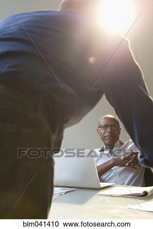 Stock Image - Businessmen talking in office. Fotosearch