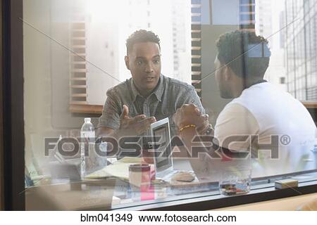 Stock Photo - Businessmen talking in office. Fotosearch