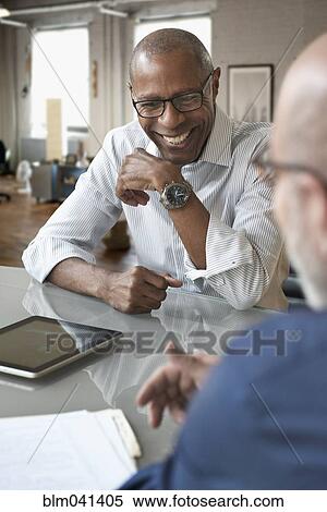 Stock Photography - Businessmen talking in office. Fotosearch