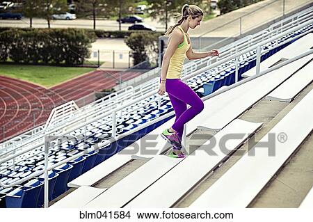 Picture - Caucasian athlete running up bleachers. Fotosearch