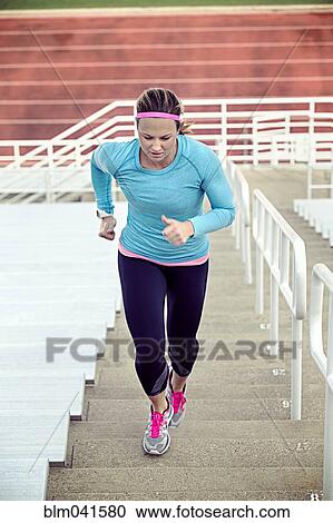 Stock Image - Caucasian athlete running up stairs. Fotosearch