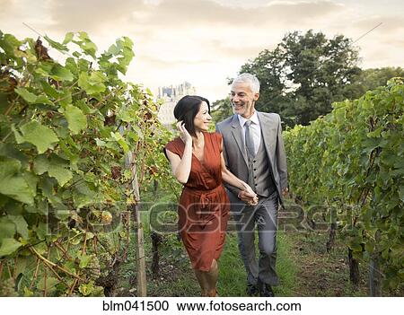 Caucasian couple walking in vineyard View Large Photo Image Stock Image - Caucasian couple walking in vineyard. Fotosearch
