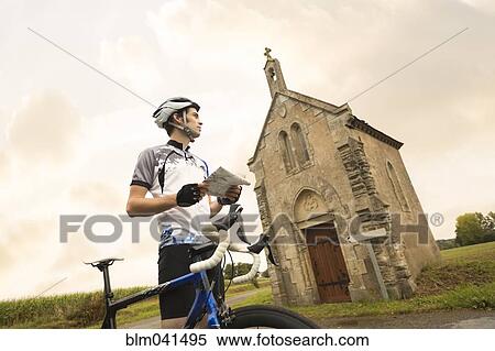 Caucasian cyclist reading map near church View Large Photo Image Stock Photography - Caucasian cyclist reading map near church. Fotosearch
