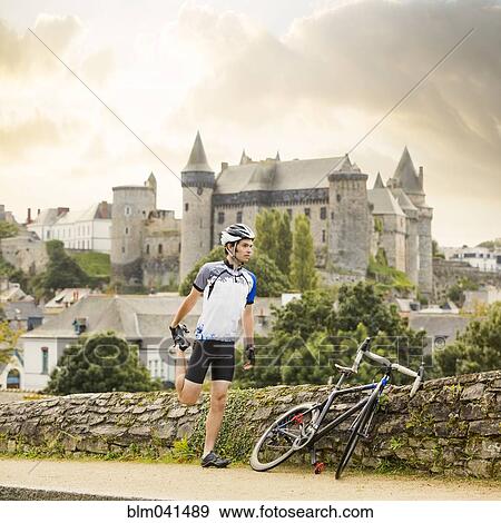 Stock Photo - Caucasian cyclist stretching outdoors. Fotosearch