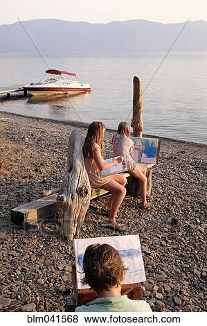 Caucasian family painting on remote lake View Large Photo Image Stock Photo - Caucasian family painting on remote lake. Fotosearch