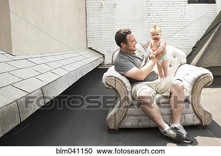 Caucasian father and baby daughter sitting in armchair outdoors View Large Photo Image Stock Image - Caucasian father and baby daughter sitting in armchair outdoors. Fotosearch