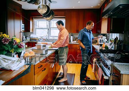 Stock Photo - Caucasian gay couple cooking in kitchen. Fotosearch