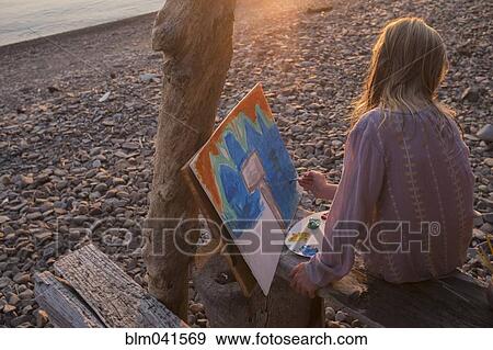 Stock Photo - Caucasian girl painting on remote lake. Fotosearch