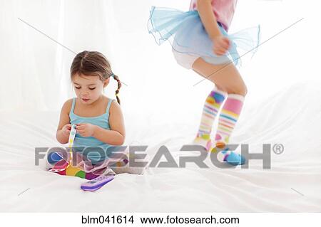 Picture - Caucasian girls playing on bed. Fotosearch