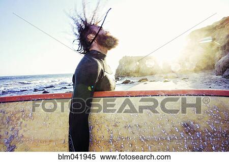 Caucasian man holding surfboard at beach View Large Photo Image Stock Photography - Caucasian man holding surfboard at beach. Fotosearch