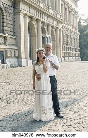 Stock Photo - Caucasian newlywed couple hugging outdoors. Fotosearch