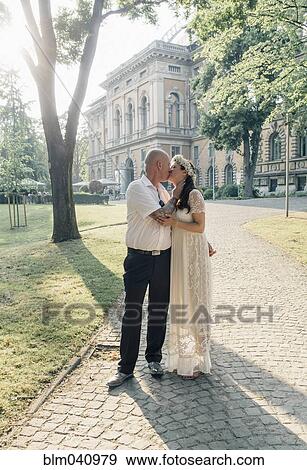 Stock Photo - Caucasian newlywed couple kissing outdoors. Fotosearch