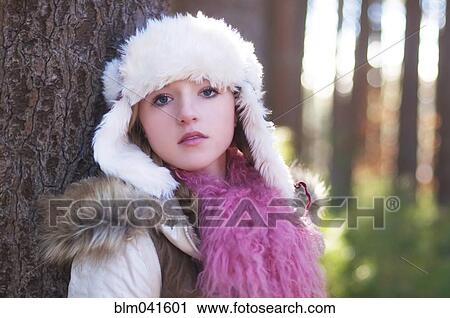 Stock Image - Caucasian teenage girl wearing fuzzy hat outdoors. Fotosearch