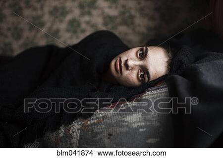 Picture - Caucasian woman laying on sofa. Fotosearch