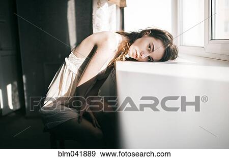 Caucasian woman leaning on windowsill View Large Photo Image Stock Photo - Caucasian woman leaning on windowsill. Fotosearch