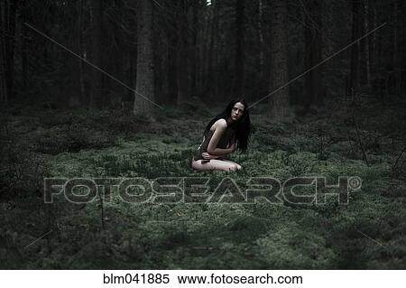 Stock Photography - Caucasian woman sitting in forest. Fotosearch