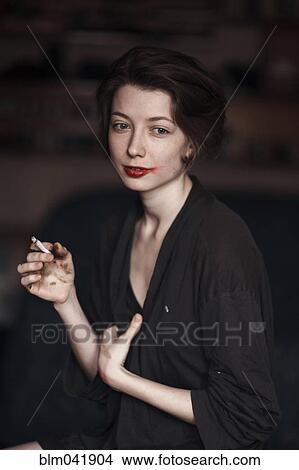 Picture - Caucasian woman smoking indoors. Fotosearch