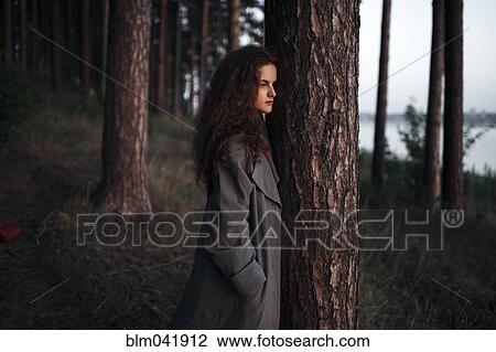 Caucasian woman standing behind tree near rural river View Large Photo Image Stock Image - Caucasian woman standing behind tree near rural river. Fotosearch